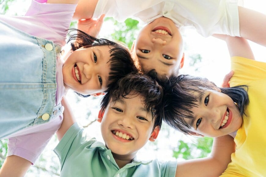 子どもが輪になって笑顔になっている写真