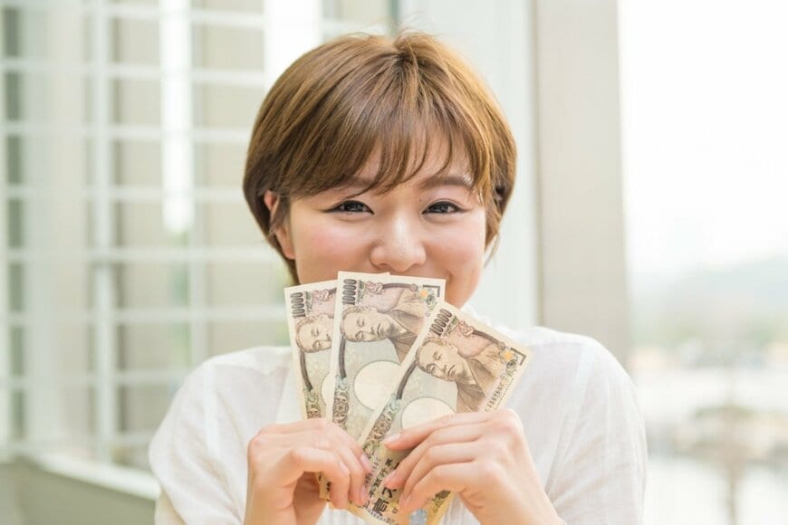 お金を持つ女性の写真