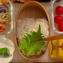 母が高校生の娘に作る「肉巻き弁当」のアイデア。胡麻で花の形にデザインしたゆで卵や、カラフルで綺麗な肉巻きを詰めた、まるでお花畑のような可愛らしいお弁当術