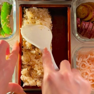 母が娘に作る【炊き込みご飯とチキンカツ弁当】ご飯の上に桜の花をちりばめたオシャレなお弁当に注目