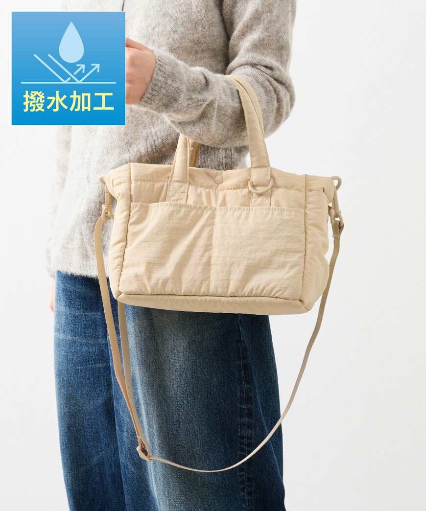 ベージュの撥水お散歩バッグを手に持った着用写真