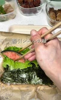 【黒とろろ昆布ののり弁】鮭に舞茸の肉巻き、がんもどきにだし巻き玉子と、海苔の上に13品を詰めていく