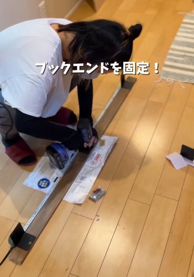 塗装した板にブックエンドを固定する様子