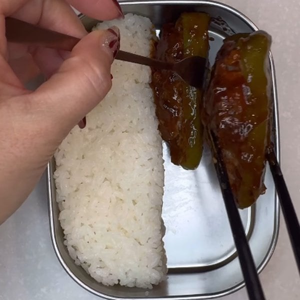 【お弁当術】主菜のピーマンの肉詰めと、黄色や赤など複数色の副菜を組み合わせたお弁当。彩りを整えてボリュームを持たせ、日々の昼食の満足度を高める献立の工夫