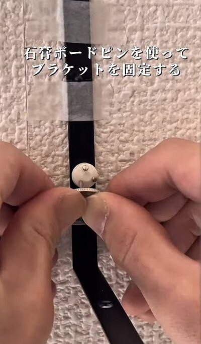 石膏ボード用ピンでブラケットを固定する工程