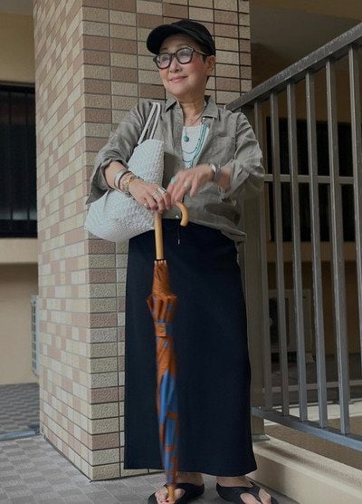 【64歳マダム】〈無印良品のリネンシャツ×しまむらの黒ロングスカート〉で上品な「雨の日コーデ」が完成　小物の差し色が爽やか
