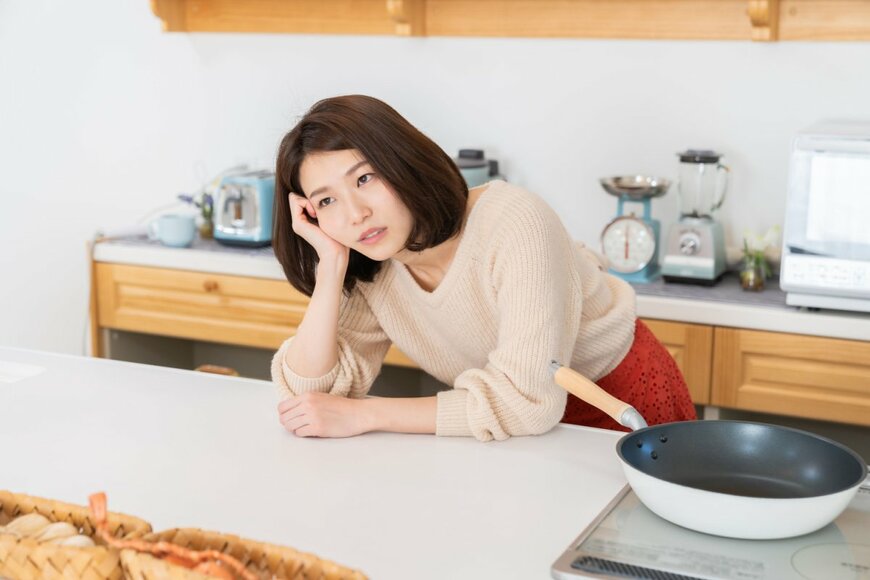 キッチンで悩んでいる女性