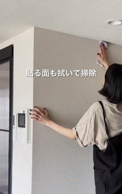 壁紙を貼る面を拭いて掃除している様子
