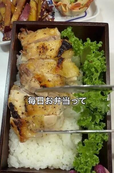 チキングリルと緑の葉野菜が並んだお弁当箱