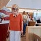 【80歳目前のマダム】鮮やかなオレンジのトップスに白のワイドパンツ。友人とのカフェへ出かける軽やかな大人コーデに「その色がとても似合っていますね」