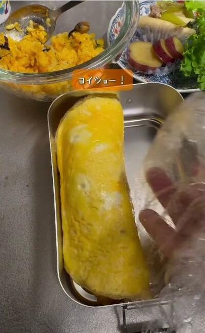 ラップで包んだオムライスをお弁当箱に収めたところ