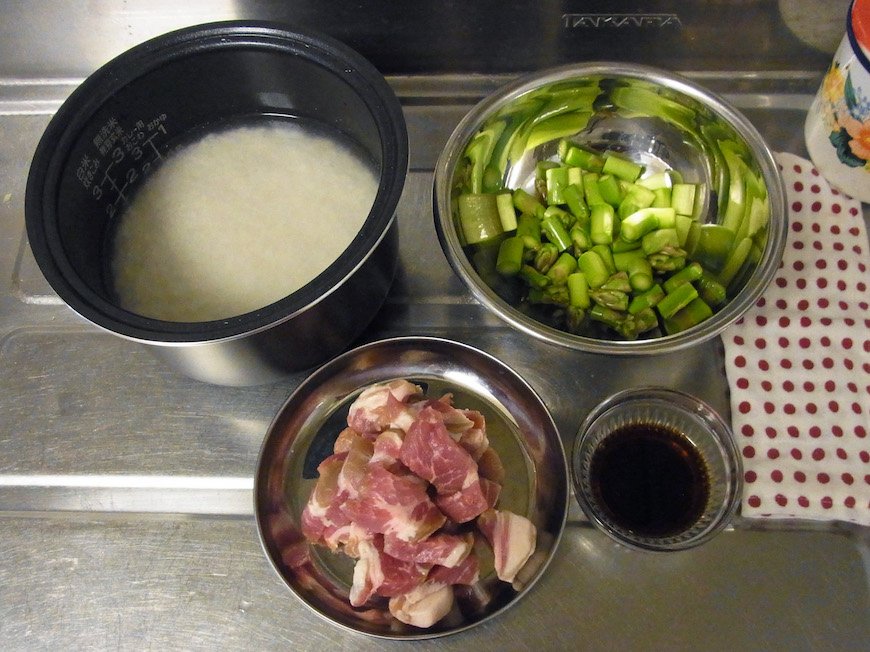 米を研ぎ、分量の水に浸す。アスパラは硬い部分を落とし、根元をピーラーでむいて食べやすい大きさに切る。塩豚は一口大に切る。