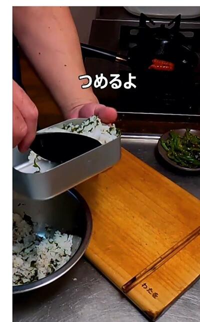 わかめとごま油を混ぜ込んだご飯を弁当箱に詰めているところ