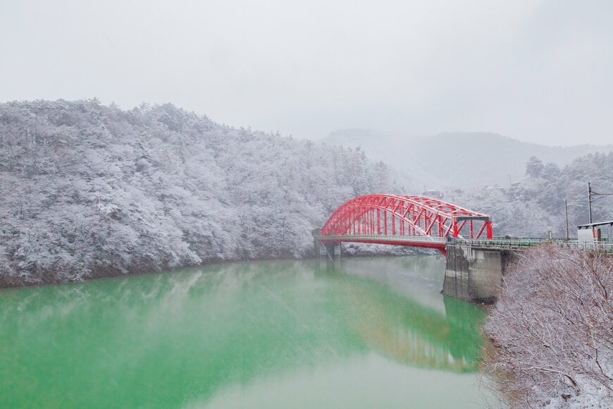 雪景色の奥多摩湖にかかったアーチ橋「峰谷橋」