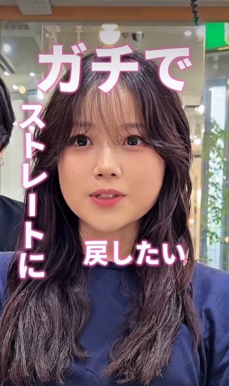 パーマスタイルのロングヘアの女性