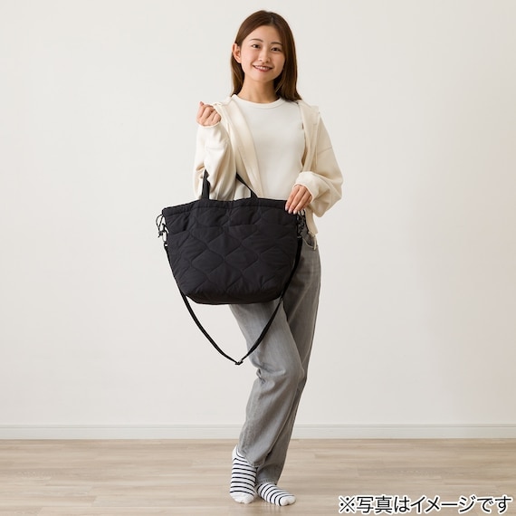 持ち手を手に提げたキルトトートバッグ