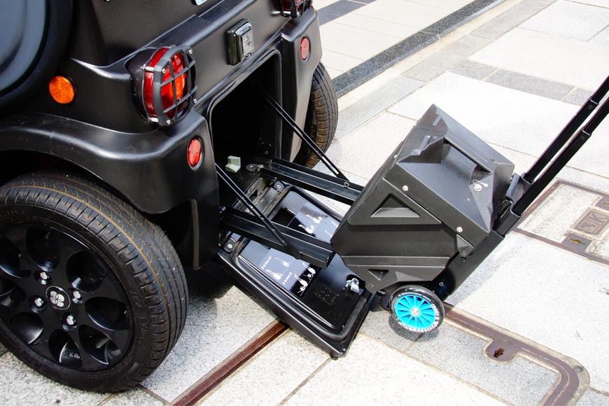 脱着式バッテリーは20kg以上の重量があるが、伸縮ハンドル＆ホイールでラクに運べる