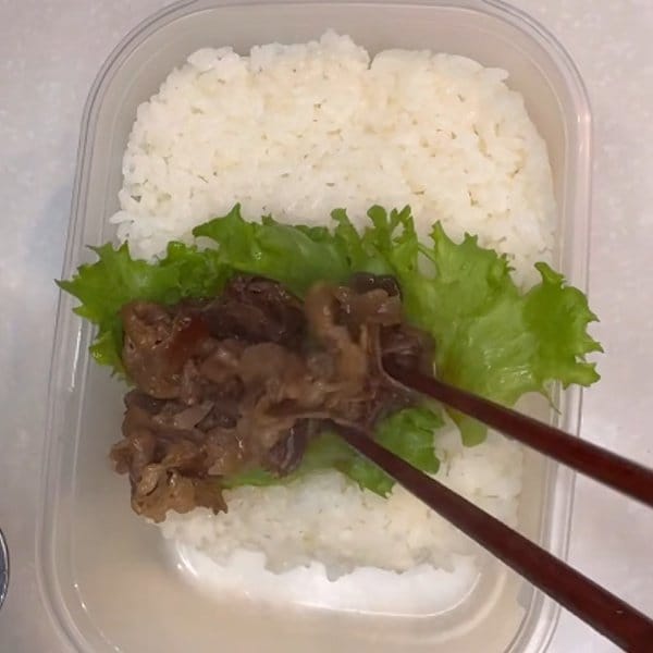 タッパーを活用した「夫弁当」のアイデア。ブロッコリーや卵焼き、焼肉などが段ごとに綺麗に分かれた、彩り豊かで美しい「焼肉弁当」の実用的な盛り付け術