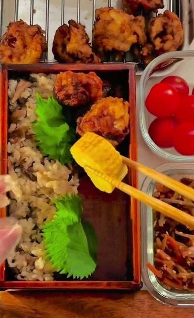 唐揚げの手前に卵焼きが並べられていくところ