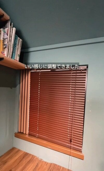 窓枠を調整し、木目調のブラインドがぴったりと収まった様子