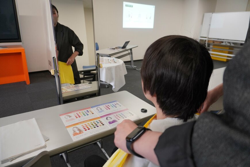 鏡の前に座っている男性と立っている女性の写真