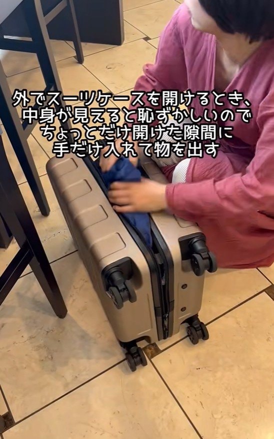 周囲を気にしながら荷物を取り出す様子