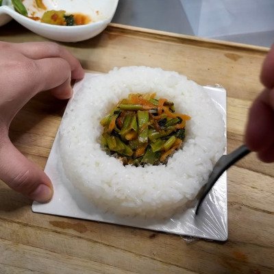 ご飯で丸い土台を作り、中心におかずを詰める