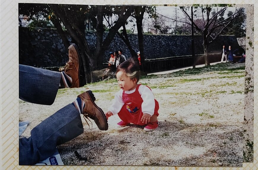転ぶ大人と見つめる少女の写真