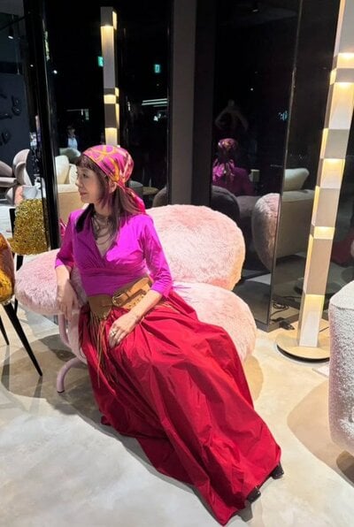 ピンクのトップスに赤のロングスカートを合わせた華やかな装い
