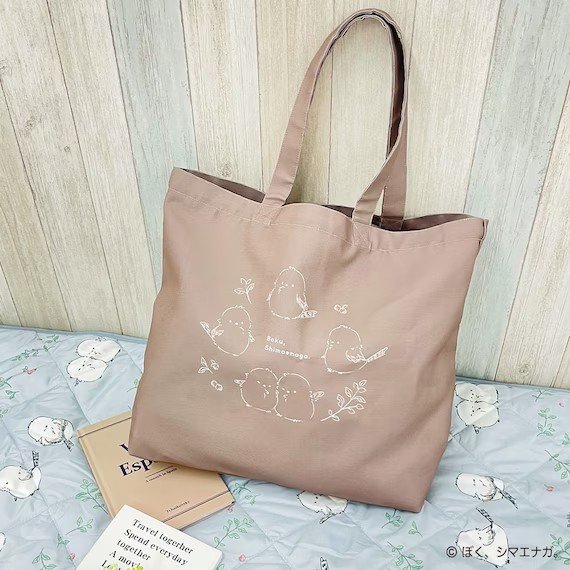 落ち着いたブラウンの生地に、様々なポーズのシマエナガたちがデザイン