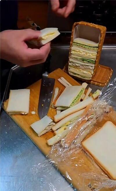 かごに詰められていくサンドイッチと、切り落とされたパンの耳