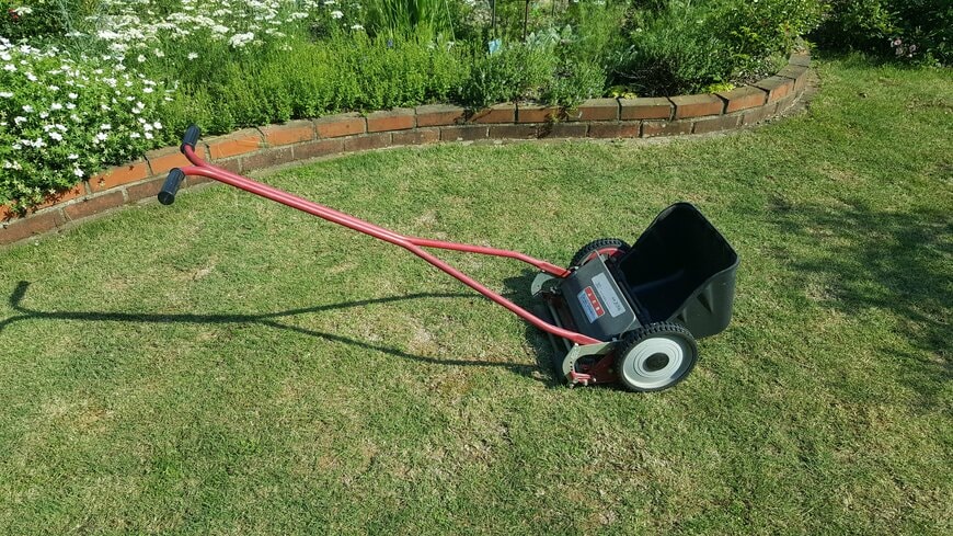 筆者の芝生の庭と手動式の芝刈り機の写真