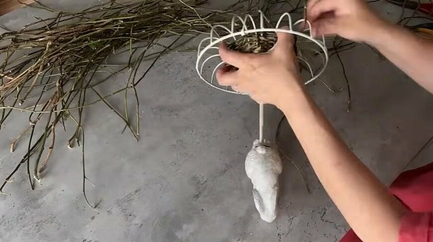 ワイヤーかごのフレームにアイビーの蔓を巻きつけて編んでいきます
