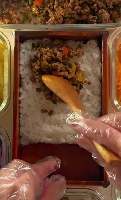 ご飯の上にガパオが広げられていくところ