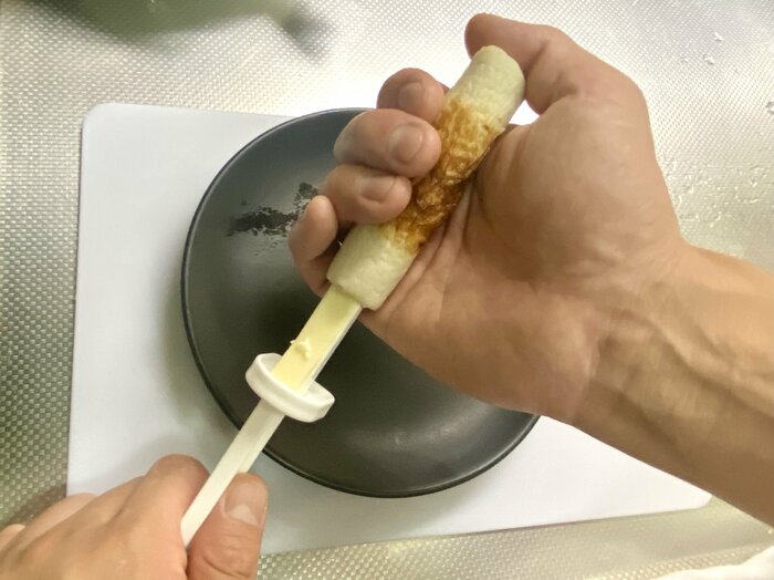 ちくわデコレーターをちくわの穴に差し込むところ