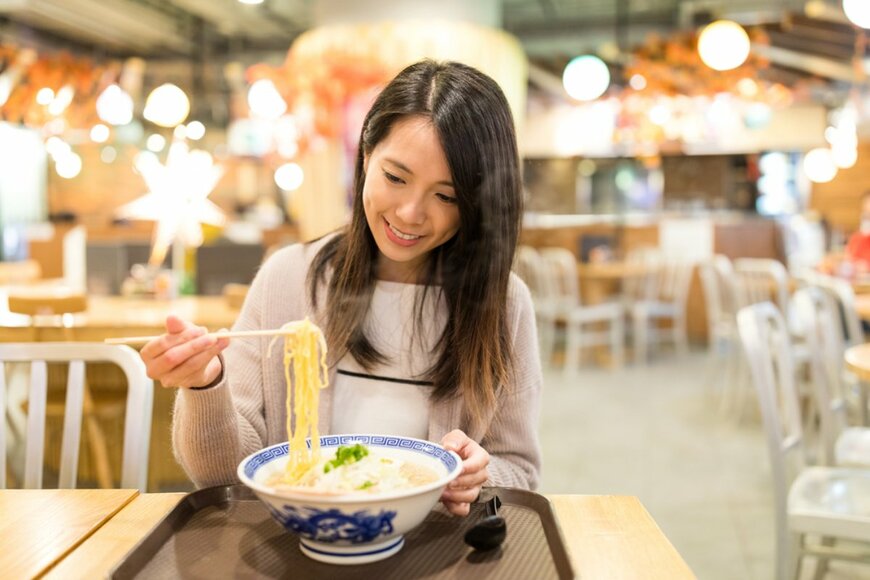 女性がひとりで食事をする写真