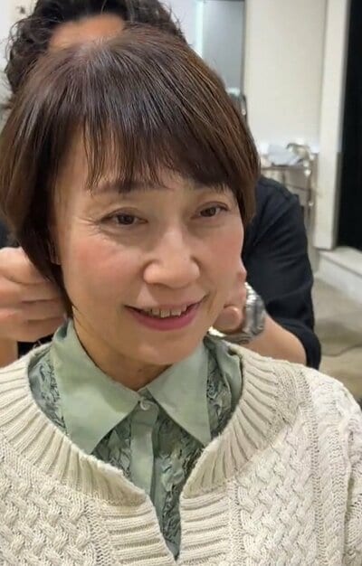 仕上がりを見て笑顔を見せる女性