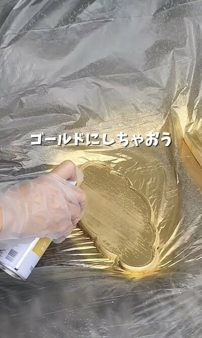 木製トレーにゴールドのラッカースプレーを吹きかけていく様子