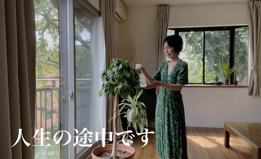 観葉植物に水をあげる60代女性