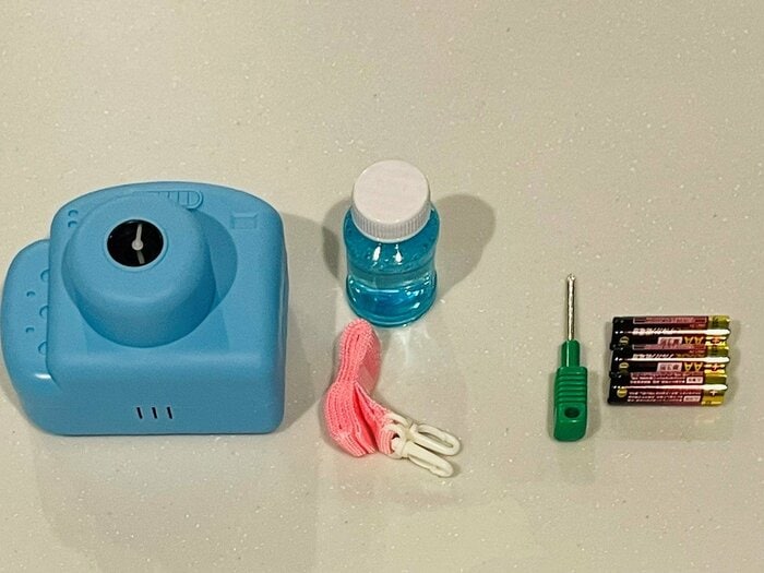 本体のカメラとシャボン液、首掛けストラップの3点が入っています