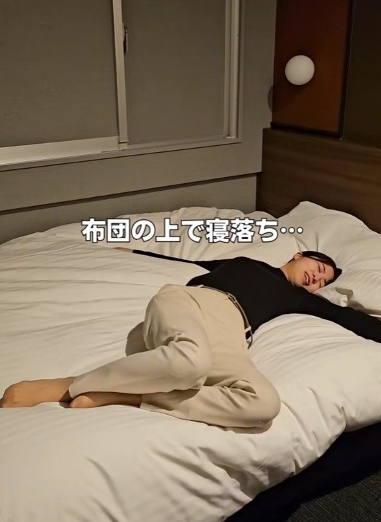 布団の上で寝落ちする女性