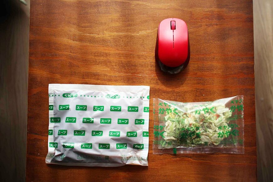 かやくのサイズも規格外。生味噌と、野菜はキャベツ、もやし、きくらげ、人参、ニラ。上部の赤いものは筆者のマウス