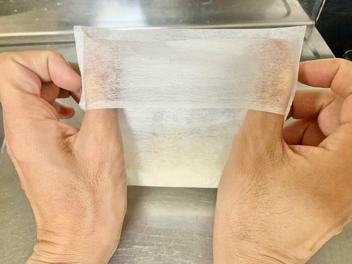 袋上部の二重になっているところに両方の親指を差し入れます