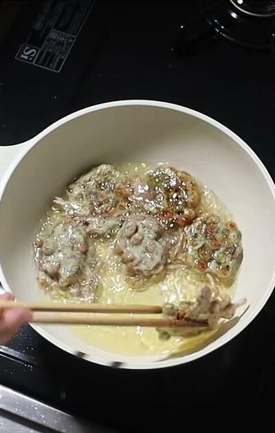 揚げ焼きにされる納豆のかき揚げ