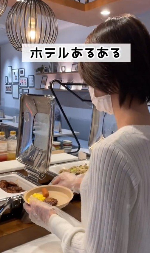 女性がスクランブルエッグなどを取る様子