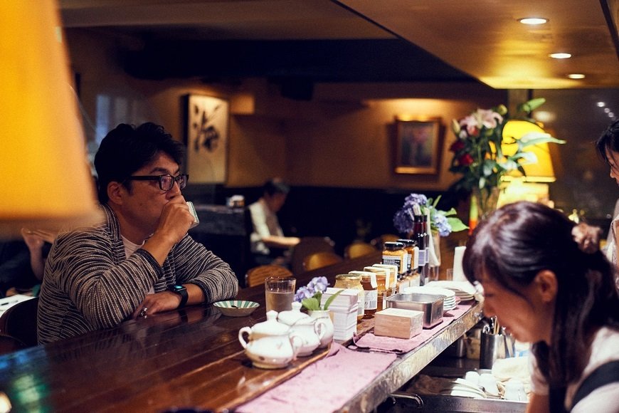 ちょっと離れた席から徳子さんをチラ見する筆者（撮影／福山楡青、以下同）