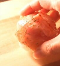 早朝から子どもにお弁当を作る50代の母。ベーコンでくるりと巻いたおにぎりをお弁当箱に組み込んだ献立の工夫と仕上がり