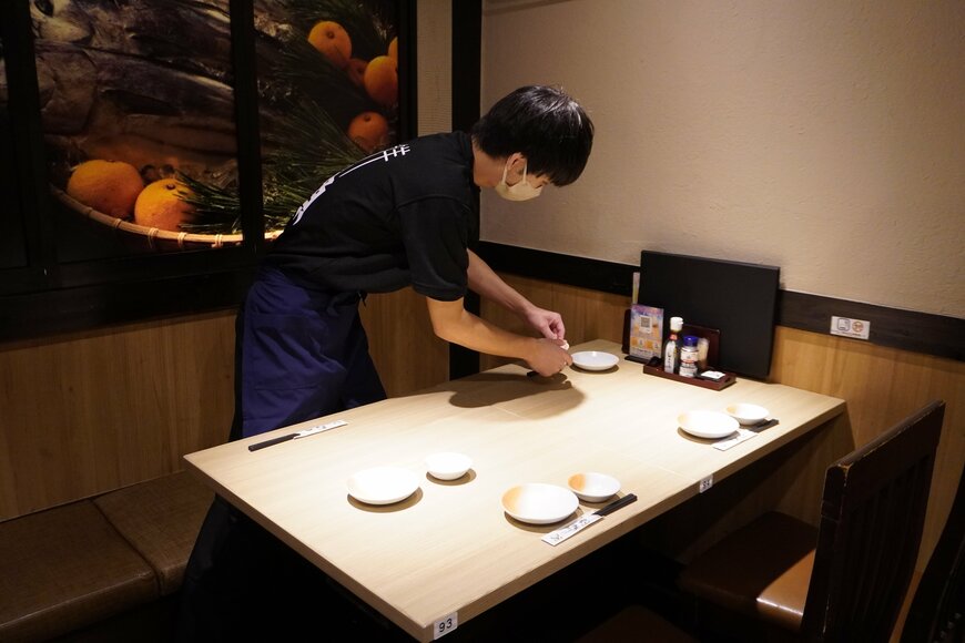 机に配膳の準備をしている男性の写真