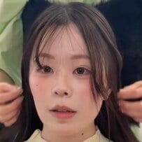 面長で額が広いと悩む女性の顔まわりを施術。前髪の幅を広げつつ長く薄めに作り、サイドの髪が自然に横に流れるように骨格をカバーするプロの技