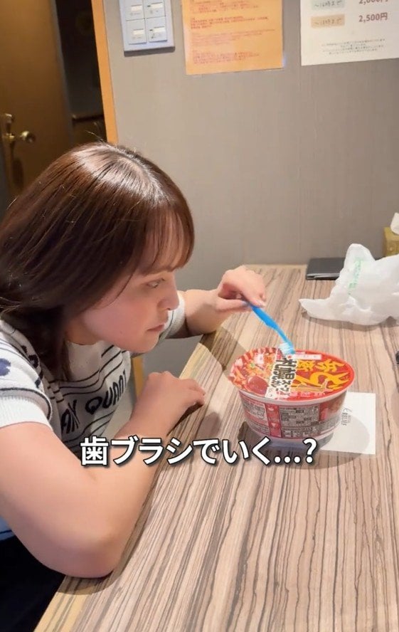 歯ブラシで食べようとする女性